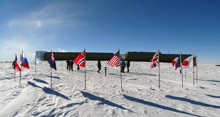 Groupe de drapeaux dans un paysage enneigé avec des personnes.