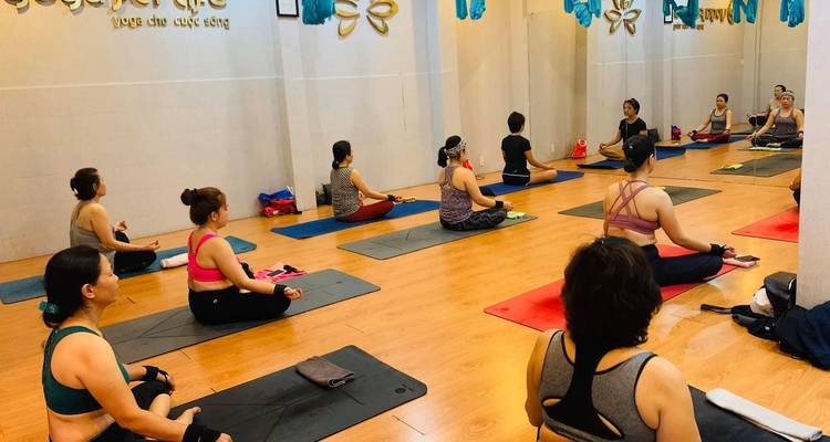 Indoor yoga class with people meditating on mats.
