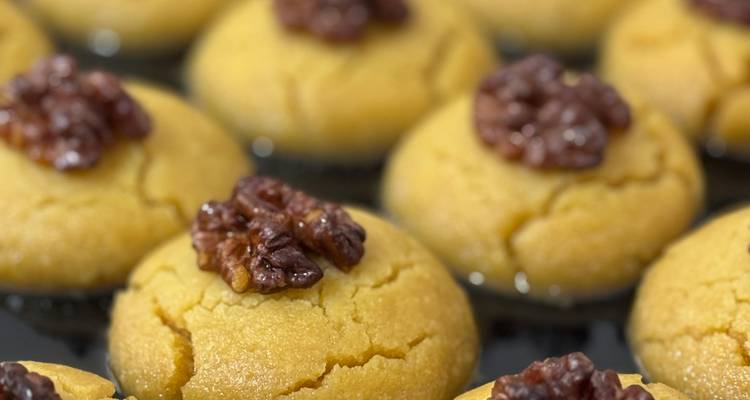 Serie de pasteles de almíbar dorado cada uno cubierto con media nuez.