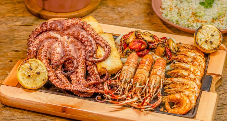 Zeevruchtenplateau herhaling met octopus, garnalen, mosselen en citroenen op hout.