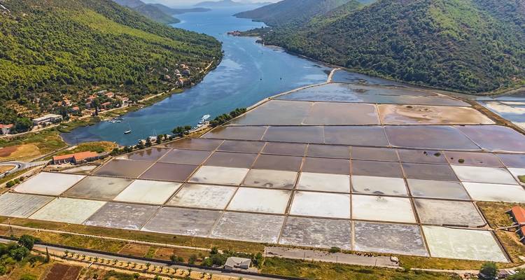 Aerial view of salt pans with a river in the background.