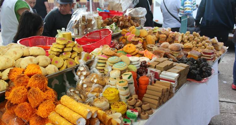 Étal de marché alimentaire coloré et diversifié avec une variété de sucreries.