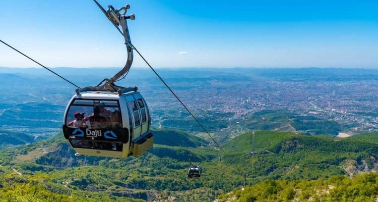 Cable car over a mountain with panoramic city view.