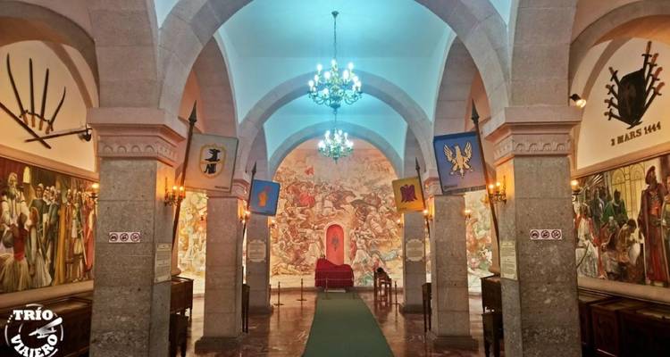 Innenraum eines Museums mit Bogengängen und historischen Gemälden.