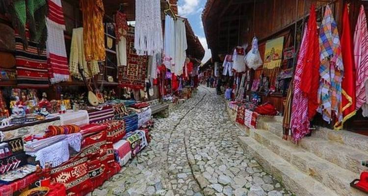 Marktstraße mit bunten Textilien und Souvenirs.
