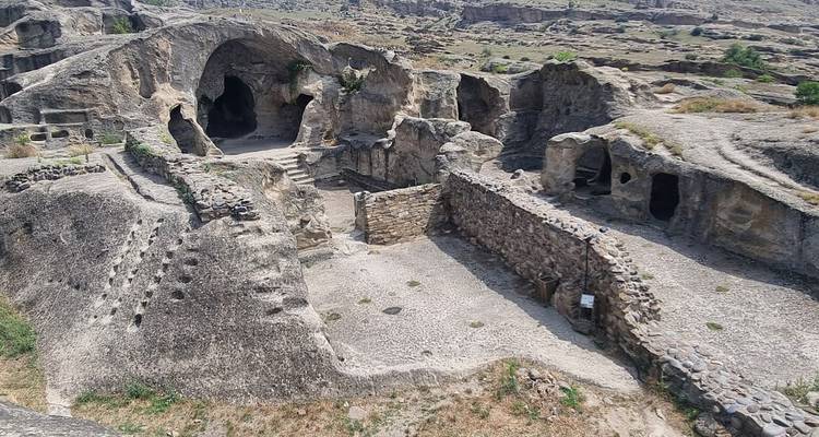 Vista aérea del complejo de cuevas excavadas en la roca de Uplistsikhe con patios y túneles.