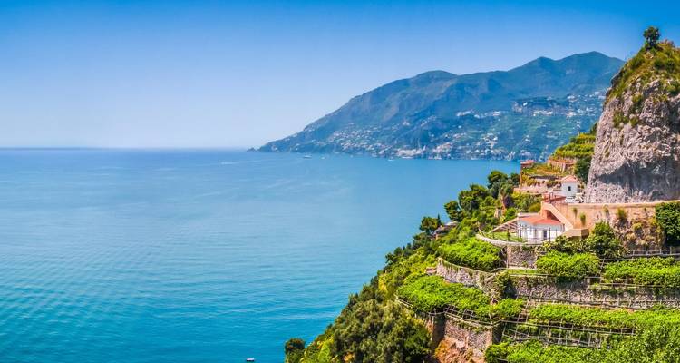 Wide coastal panorama of the Amalfi Coast with terraced hillsides and deep blue Mediterranean Sea.