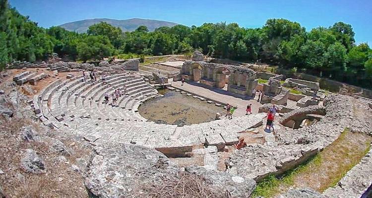Amfitheater met een paar mensen die de ruïnes verkennen.