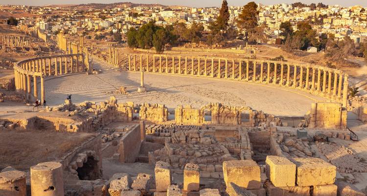 Panoramisch uitzicht op oude ruïnes met een moderne stad op de achtergrond.