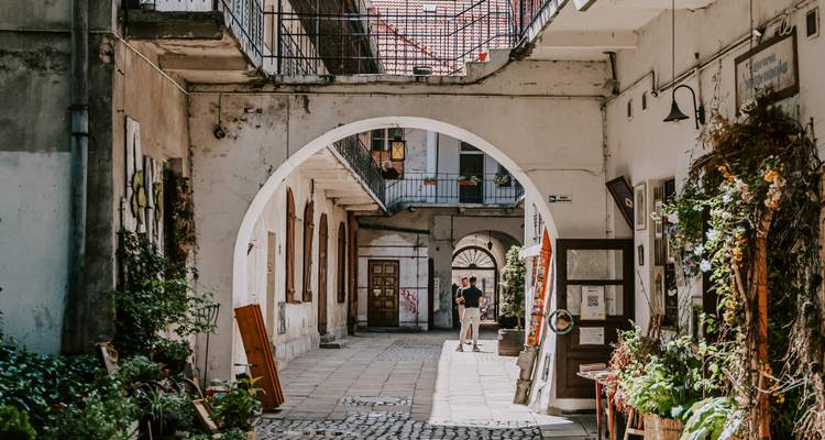 Une cour historique avec des arches et un chemin pavé.