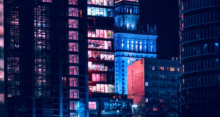 Bâtiments modernes la nuit avec un éclairage coloré.