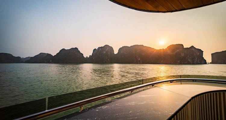 Vista del atardecer desde la cubierta de un crucero a través de los karsts calizos de la Bahía de Halong.