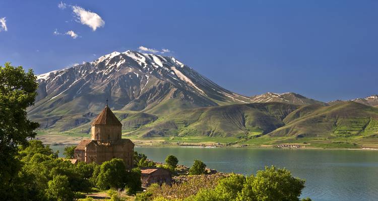 Iglesia histórica con montaña al fondo, probablemente en la isla de Akdamar.