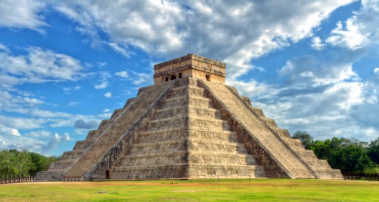 Pyramid of Kukulkan at Chichen Itza under a cloudy sky.