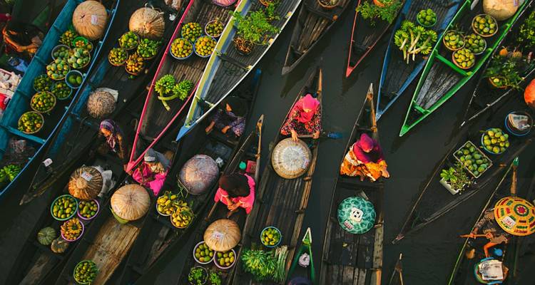 Vue aérienne colorée de bateaux de marché flottant sur une rivière.