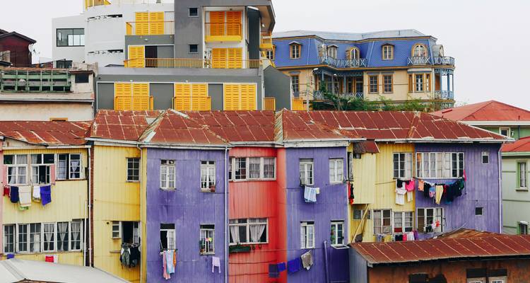 Fila de casas de chapa ondulada coloridas en Valparaíso con ropa colgando de las ventanas.