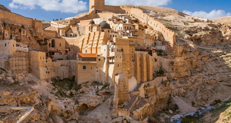 Eine festungsartige antike Gebäude, das in die Felswand hineingebaut ist.