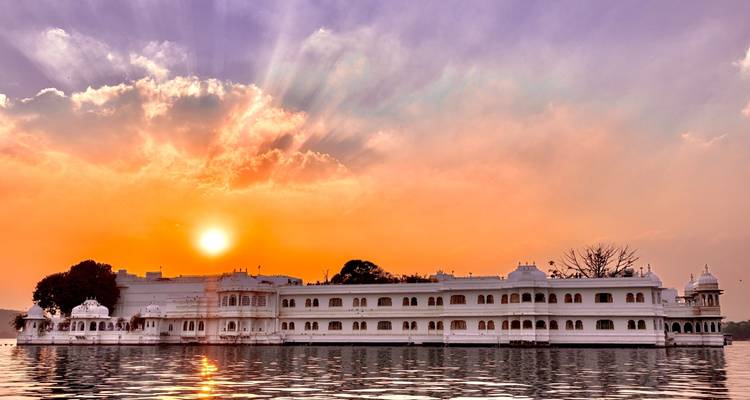 Palace on a lake with a vibrant sunset.