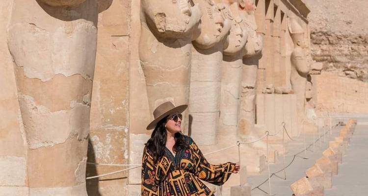 Femme posant à côté de statues dans un temple égyptien.