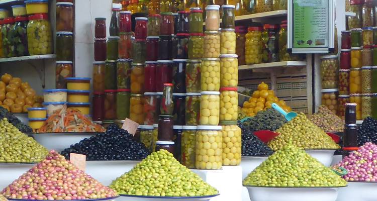 Kleurrijke etalage van potten en voedingsmiddelen op een markt.
