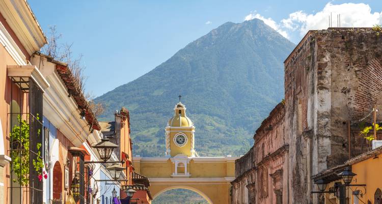 Gelber Santa Catalina Bogen, der einen Vulkangipfel in einer Kolonialstraße von Antigua einrahmt