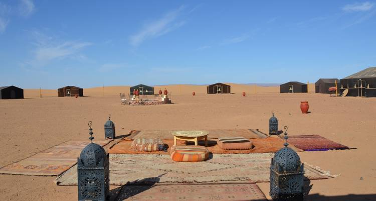 Desert camp with colorful cushions and traditional lanterns.