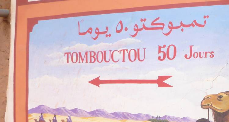 Sign with direction to Tombouctou and text in Arabic.