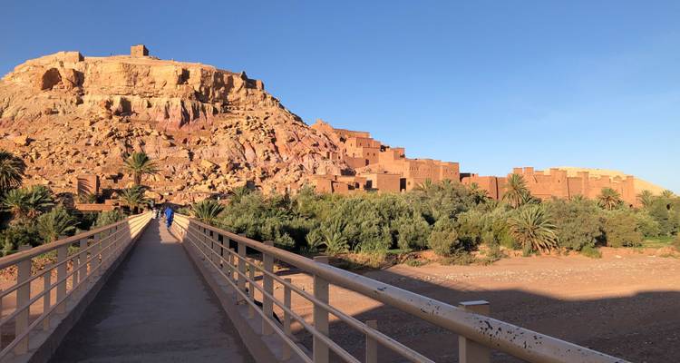 Bridge leading to an ancient fortress built into a hillside.
