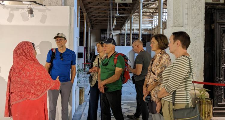 A tour guide talking to een groep toeristen in een museum.

Wait, let me provide a more natural Dutch translation:

Een gids die praat tegen een groep toeristen in een museum.

Or alternatively:

Een museumgids die spreekt tot een groep toeristen.