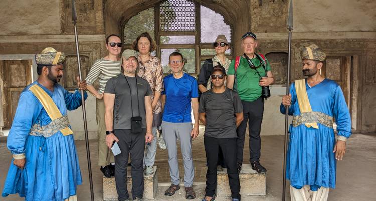 Toeristen met locals in traditionele kledij op een historische locatie