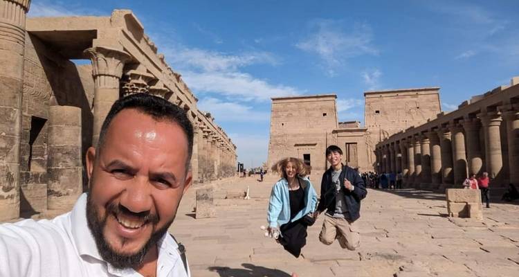 Touristen posieren vor den Ruinen eines antiken Tempels.