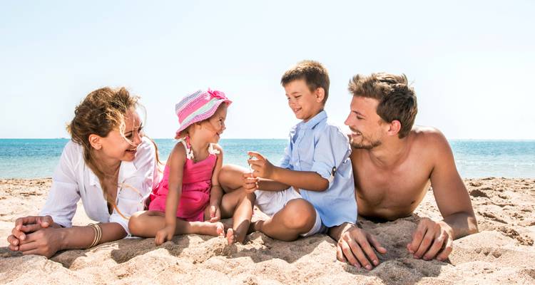 Une famille avec deux enfants profitant d'une plage ensoleillée.