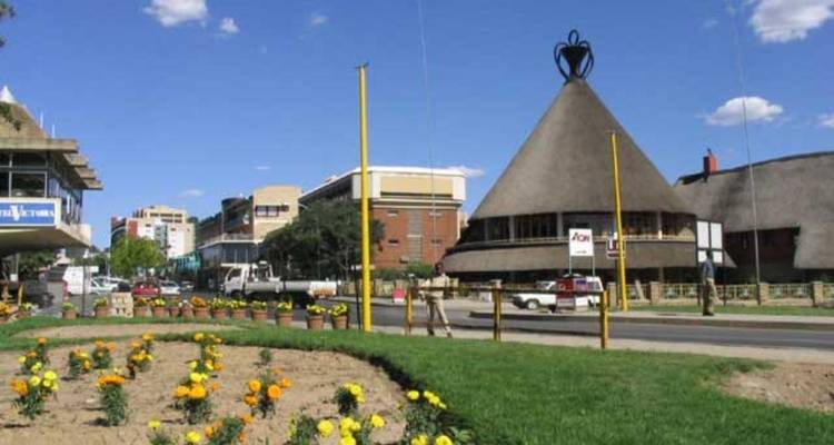 A street in Maseru featuring traditional buildings and flowerbeds.