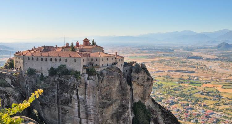 Monasterio en un acantilado con vista expansiva del valle.