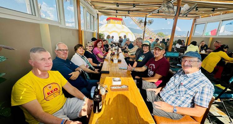 Groupe de personnes assises dans un restaurant avec vue sur un grand stupa.