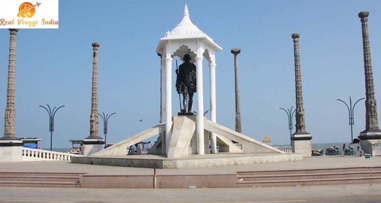 Statue de Gandhi sous un dais avec des piliers ornementaux en arrière-plan.