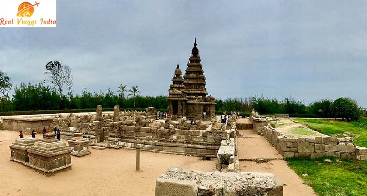Temple en pierre avec des sculptures détaillées entouré de verdure.