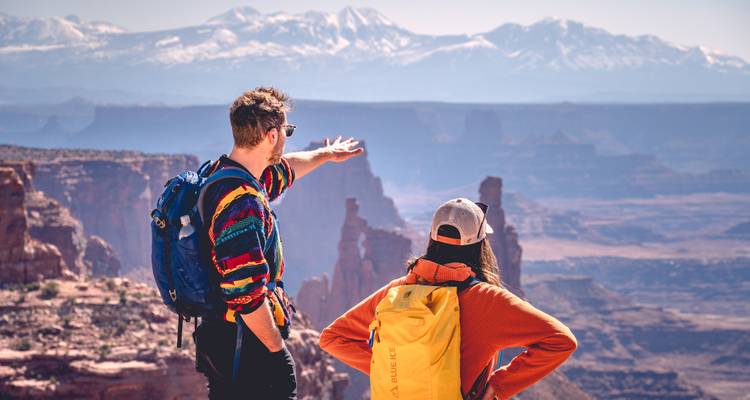 Dos excursionistas contemplando un paisaje de cañón.