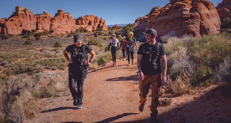 Grupo de personas caminando por un sendero en un paisaje desértico.