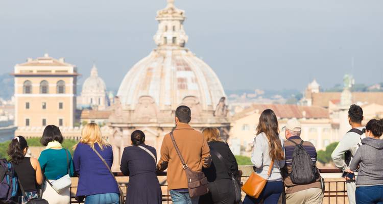 A group of people observing a cityscape with a large domed building.