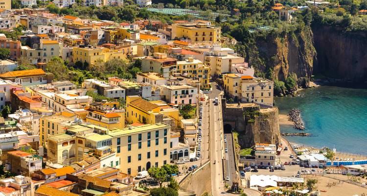 Colorful coastal town with Mediterranean architecture and a view of the sea.
