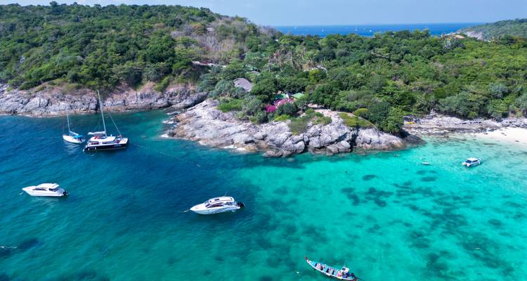 Luftaufnahme einer tropischen Insel mit Jachten und blauem Wasser.