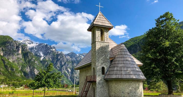 Encantadora iglesia con telón de fondo montañoso en Theth.
