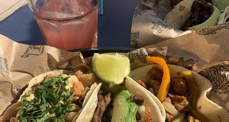 Tacos assortis et une boisson sur une table.