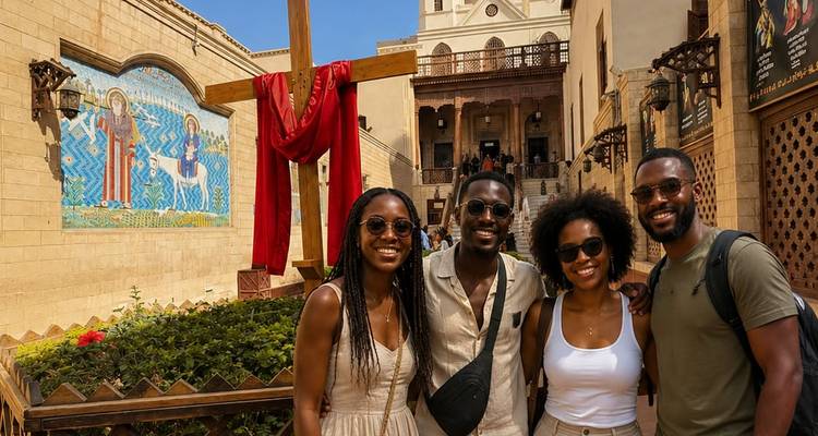 Quatre amis posant devant une grande croix en bois et une mosaïque colorée au Vieux Caire.