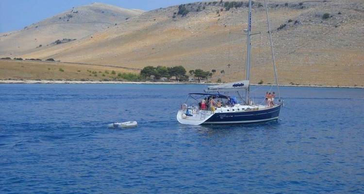 Sailboat on calm water with mountains in the background.