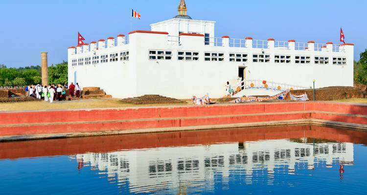Reflejo de una estupa blanca en un estanque en un día soleado.