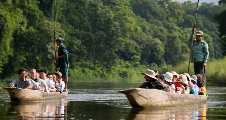 Turistas disfrutando de un paseo en canoa en un río exuberante y tranquilo.