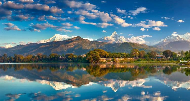 Reflejo de montañas en un lago bajo un cielo vibrante.