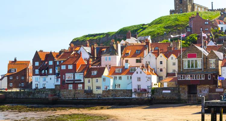 Colorful houses along a coastal area with a historic building.